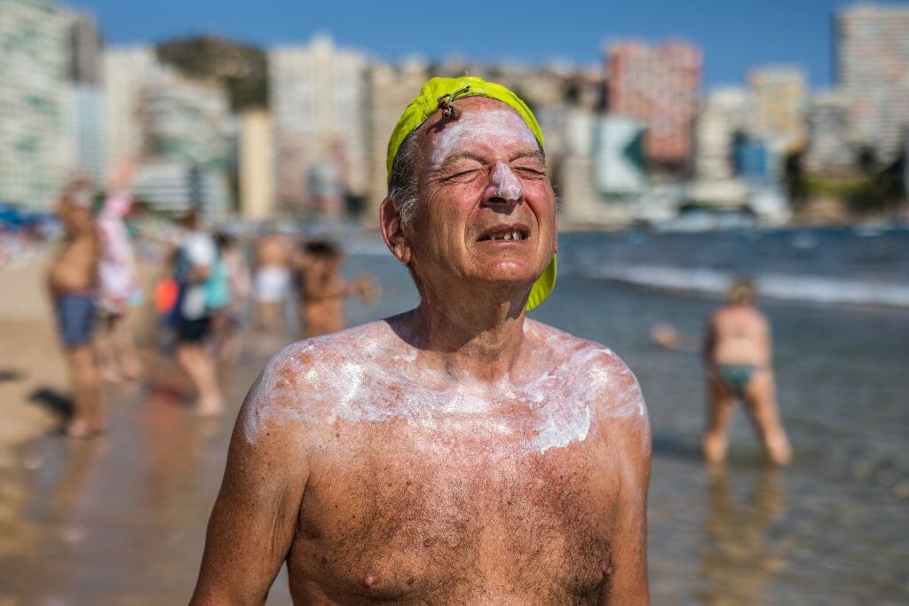 Un hombre intenta soportar el fuerte calor en una playa en Benidorm