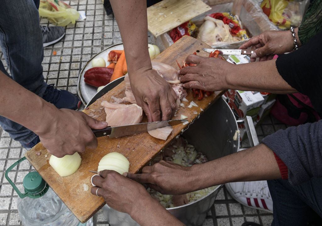 Voluntarios preparan alimentos en una olla común en Sudamérica