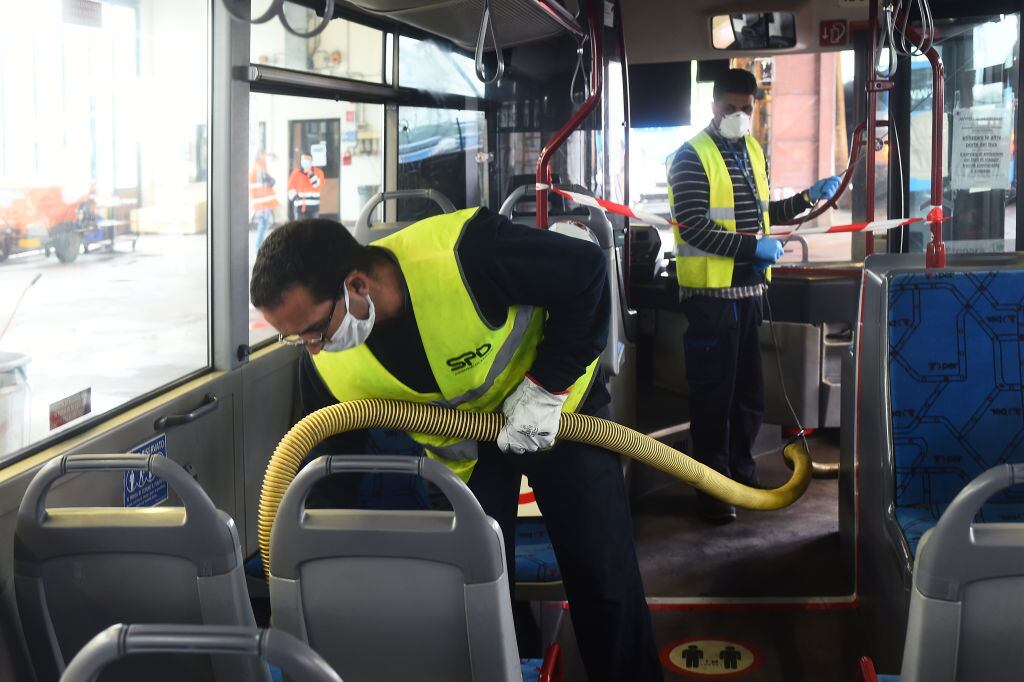 Trabajadores desinfectan los buses en Bolonia