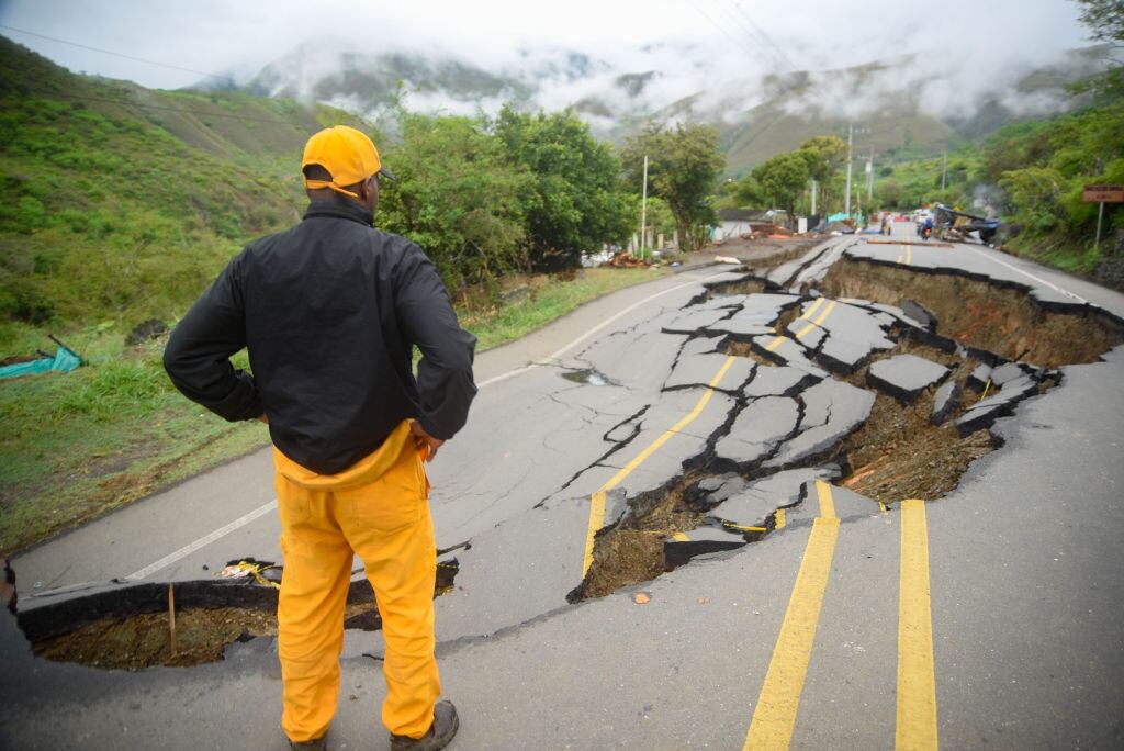 Hombre observa daño en carretera de Colombia por cambio climático