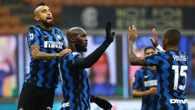 MILAN, ITALY - DECEMBER 20: Romelu Lukaku of Inter Milan celebrates with (l-r) Arturo Vidal and Ashley Young after scoring their sides second goal from a penalty during the Serie A match between FC Internazionale and Spezia Calcio at Stadio Giuseppe Meazza on December 20, 2020 in Milan, Italy. Sporting stadiums around Italy remain under strict restrictions due to the Coronavirus Pandemic as Government social distancing laws prohibit fans inside venues resulting in games being played behind closed doors. (Photo by Marco Luzzani/Getty Images)