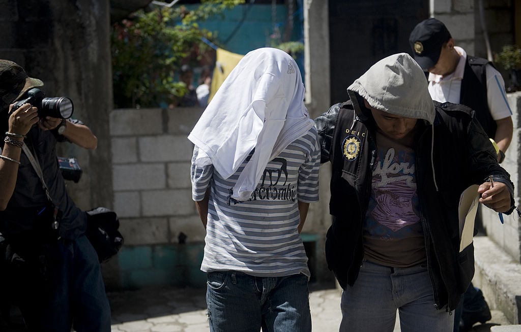 Policías de Guatemala llevan prisioneros a un criminal acusado de asesinato