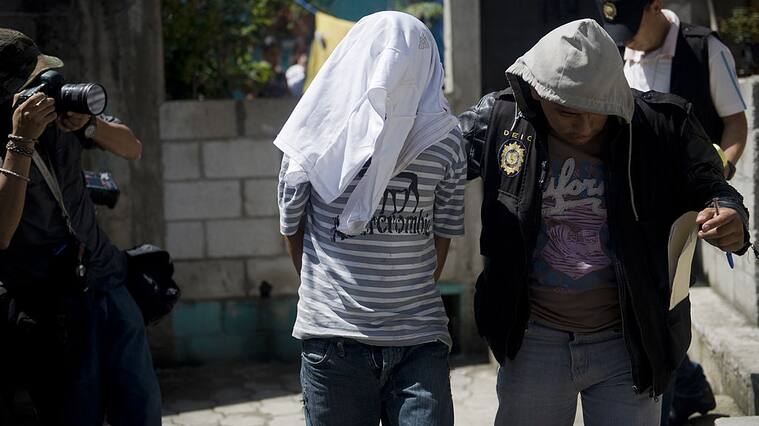Policías de Guatemala llevan prisioneros a un criminal acusado de asesinato