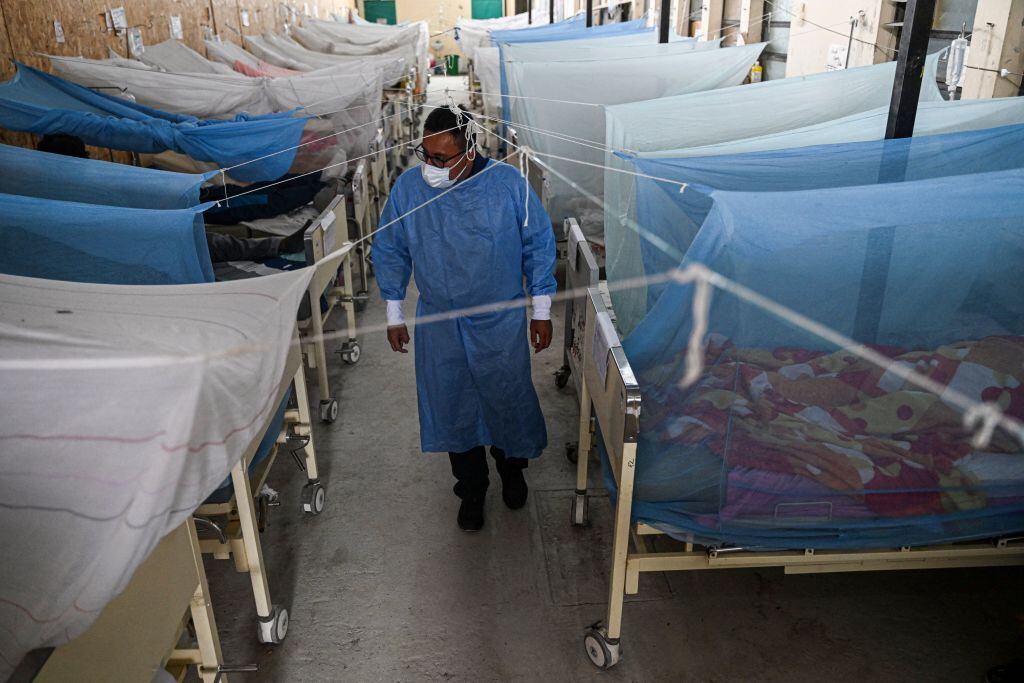 Un médico observa a pacientes contagiados por el mosquito del dengue en un centro médico en Piura del Perú.