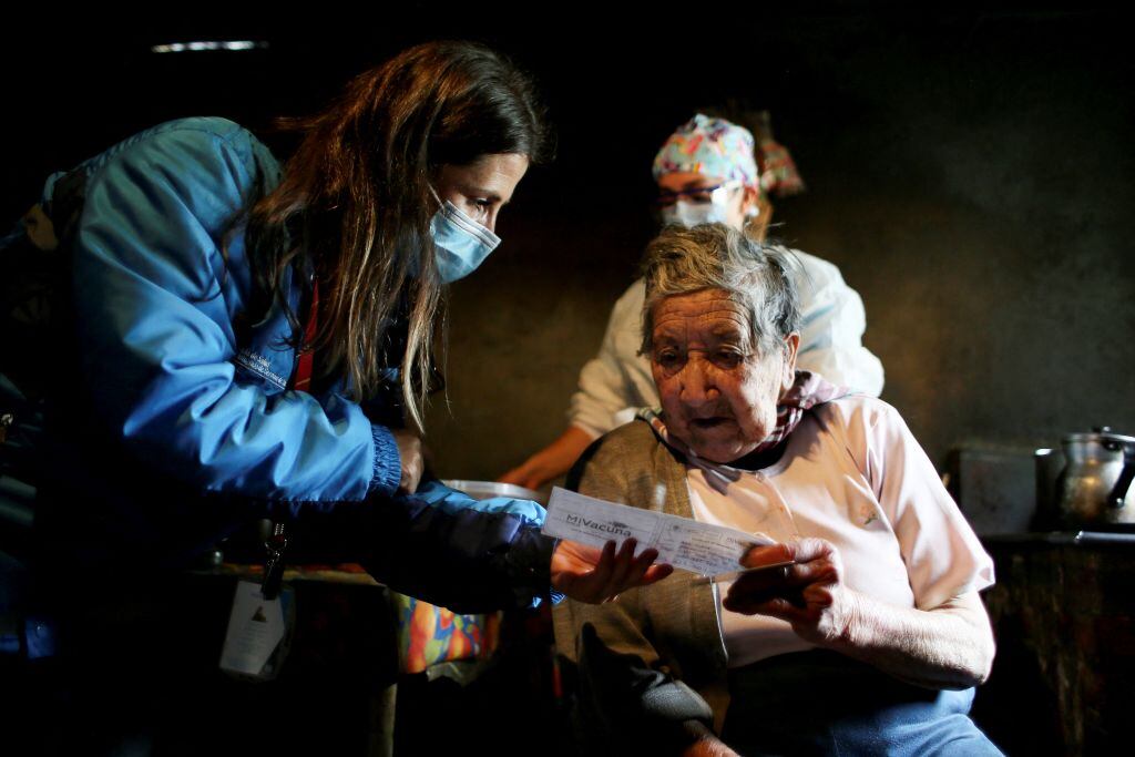 Vecina recibe su certificado de vacunación contra el Covid-19 en Colombia