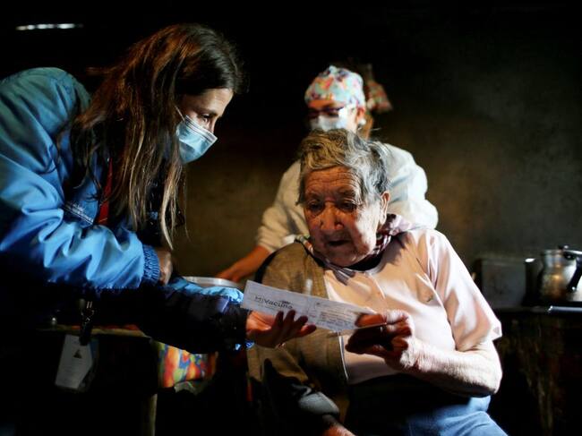 Vecina recibe su certificado de vacunación contra el Covid-19 en Colombia