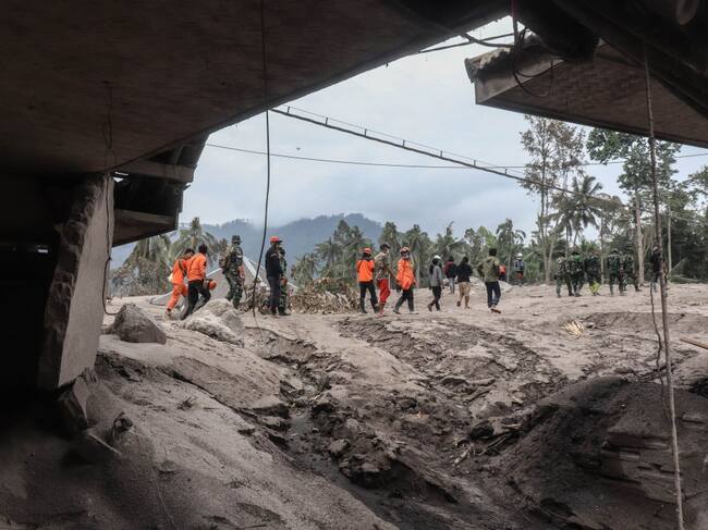 Rescatistas observan la destrucción que dejó la erupción en la villa Lumajang