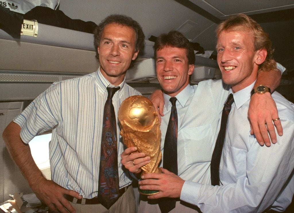 Andreas Brehme sostiene la copa del Mundo en 1990 en Roma, acompañado de Lothar Matthäus y Franz Beckenbauer tras ser campeón con Alemania.