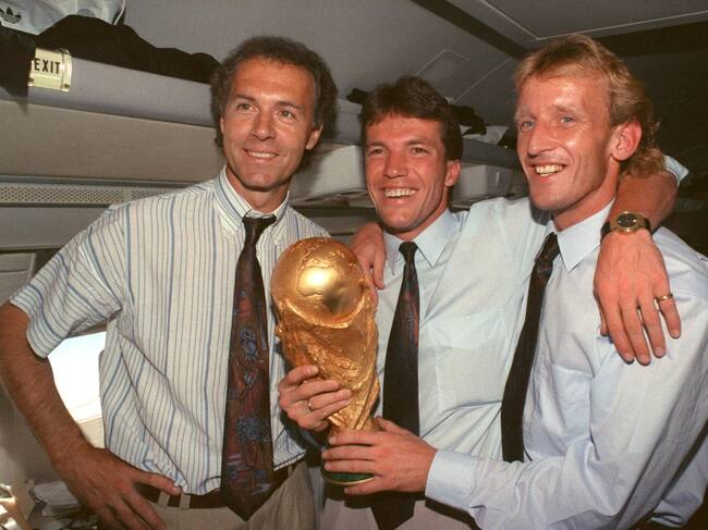 Andreas Brehme sostiene la copa del Mundo en 1990 en Roma, acompañado de Lothar Matthäus y Franz Beckenbauer tras ser campeón con Alemania.