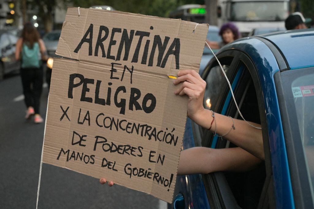 Una persona levanta un cartel contra el Plan Milei al pasar por las afueras del Congreso de Argentina en la ciudad de Buenos Aires.
