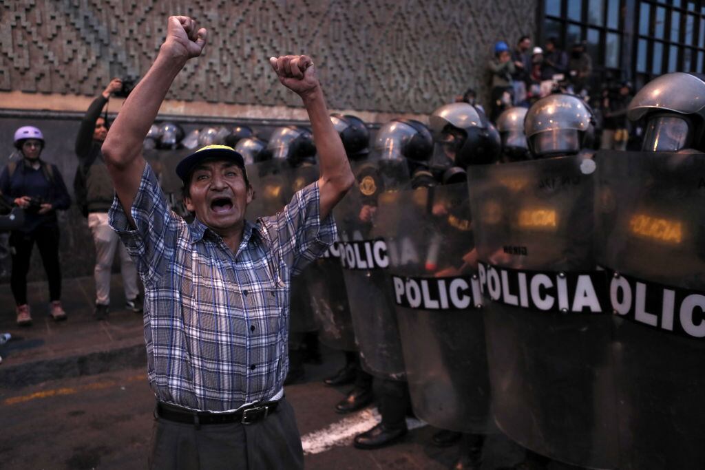 Hombre protestas frente a la policía en la ciudad de Lima en Perú