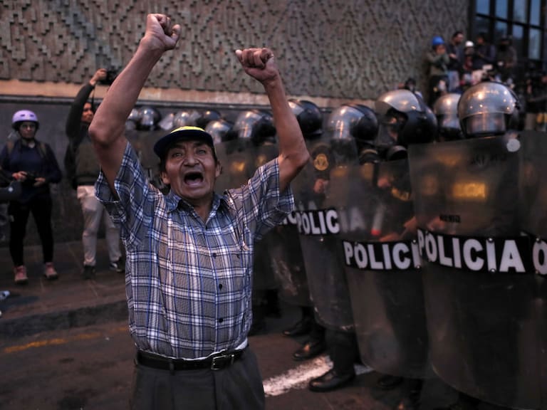 Hombre protestas frente a la policía en la ciudad de Lima en Perú