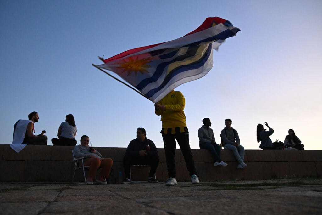 Una persona con la bandera de Uruguay en la zona de la Rambla en la ciudad de Montevideo
