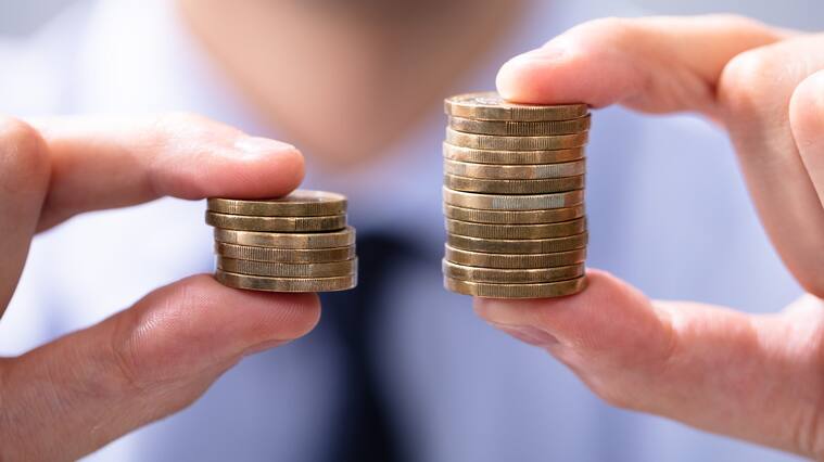Man Holding Two Coin Stacks To Compare