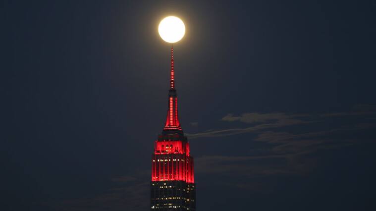 UNION CITY, NJ - APRIL 7: The Super Pink Moon rises behind the Empire State in New York City lit to honor COVID-19 healthworkers on April 7, 2020 as seen from Union City, New Jersey. (Photo by Gary Hershorn/Getty Images)