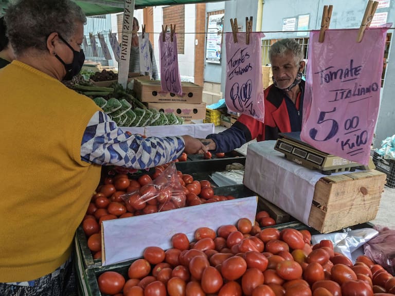 Una mujer compra en una feria de verduras en Brasil