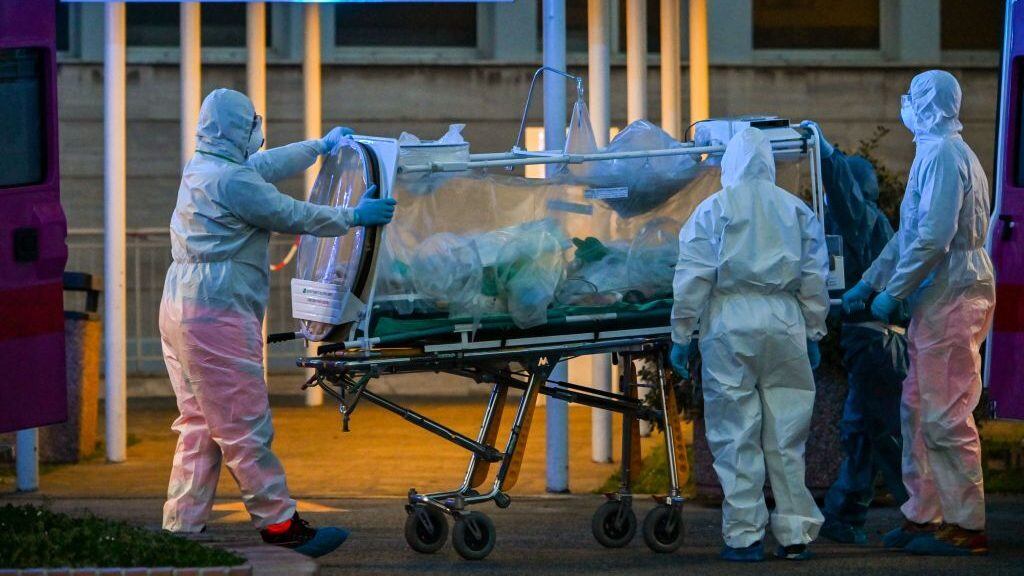 Medical workers in overalls stretch a patient under intensive care into the newly built Columbus Covid 2 temporary hospital to fight the new coronavirus infection, on March 16, 2020 at the Gemelli hospital in Rome. (Photo by ANDREAS SOLARO / AFP) (Photo by ANDREAS SOLARO/AFP via Getty Images)