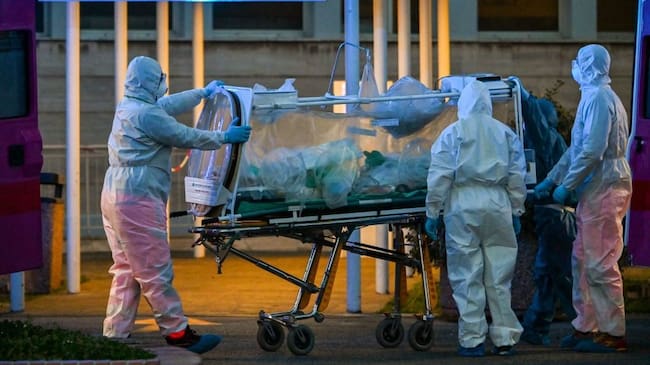 Medical workers in overalls stretch a patient under intensive care into the newly built Columbus Covid 2 temporary hospital to fight the new coronavirus infection, on March 16, 2020 at the Gemelli hospital in Rome. (Photo by ANDREAS SOLARO / AFP) (Photo by ANDREAS SOLARO/AFP via Getty Images)