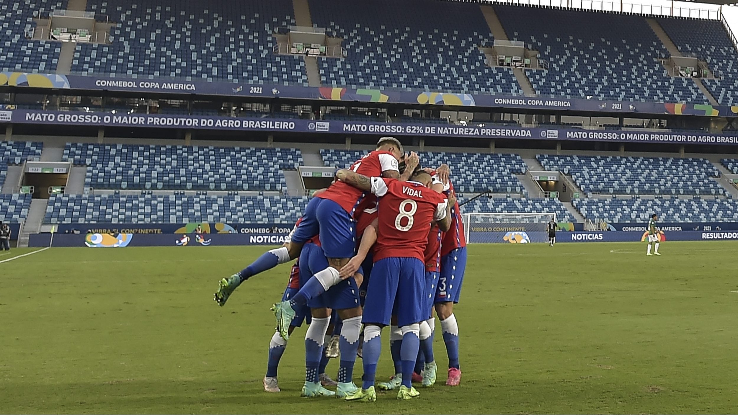 Players of Chile celebrate after teammate Ben Brereton (covered) scored against Bolivia during their Conmebol Copa America 2021 football tournament group phase match at the Pantanal Arena in Cuiaba, Brazil, on June 18, 2021. (Photo by Douglas Magno / AFP) (Photo by DOUGLAS MAGNO/AFP via Getty Images)