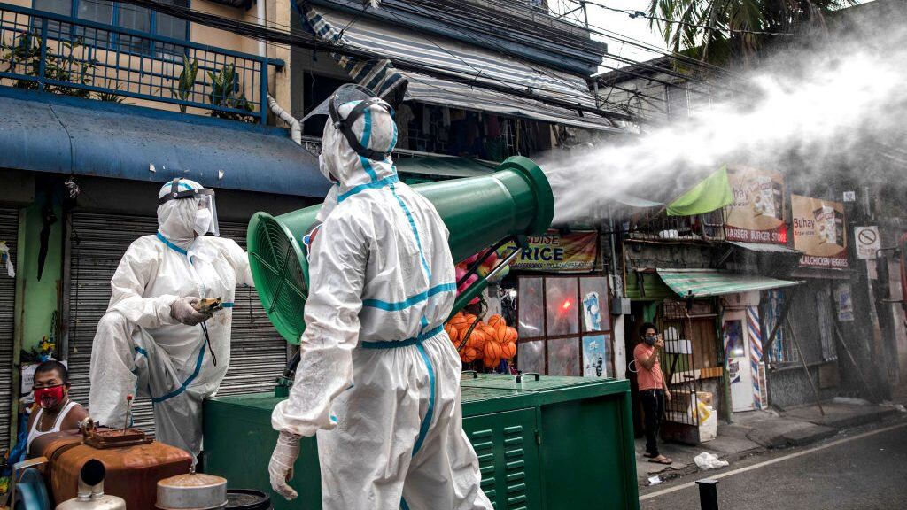 SAN JUAN, PHILIPPINES - MARCH 23: Disinfection workers spray disinfectant from a water cannon along a street at a suburban area on March 23, 2020 in San Juan, Metro Manila, Philippines. The Philippine government has sealed off Luzon, the country's largest and most populous island, to prevent the spread of COVID-19. Land, sea, and air travel has been suspended, while government work, schools, businesses, and public transportation have been ordered shut in a bid to keep some 55 million people at home. The Philippines' Department of Health has so far confirmed 462 cases of the new coronavirus in the country, with at least 33 recorded fatalities. (Photo by Ezra Acayan/Getty Images)