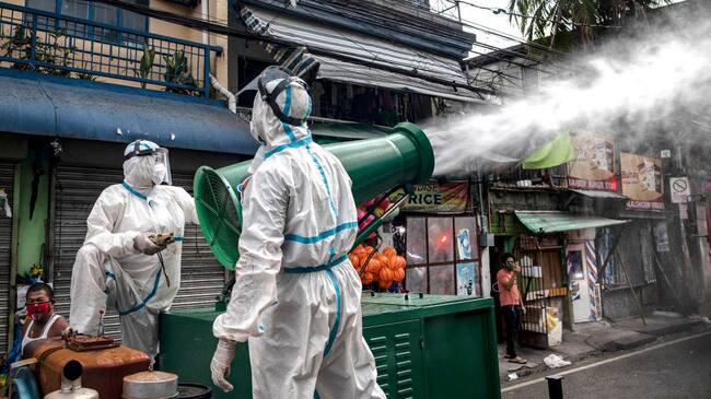 SAN JUAN, PHILIPPINES - MARCH 23: Disinfection workers spray disinfectant from a water cannon along a street at a suburban area on March 23, 2020 in San Juan, Metro Manila, Philippines. The Philippine government has sealed off Luzon, the country's largest and most populous island, to prevent the spread of COVID-19. Land, sea, and air travel has been suspended, while government work, schools, businesses, and public transportation have been ordered shut in a bid to keep some 55 million people at home. The Philippines' Department of Health has so far confirmed 462 cases of the new coronavirus in the country, with at least 33 recorded fatalities. (Photo by Ezra Acayan/Getty Images)