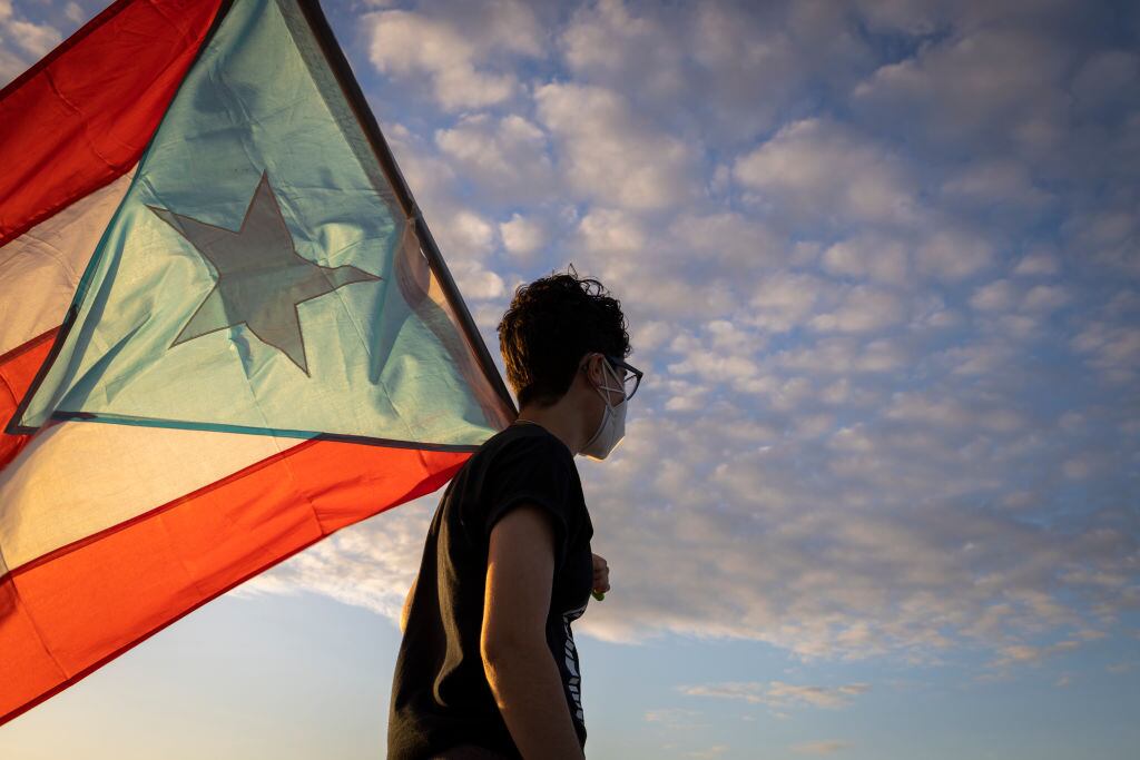 Una persona porta una bandera de Puerto Rico en la ciudad de San Juan