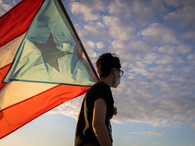 Una persona porta una bandera de Puerto Rico en la ciudad de San Juan