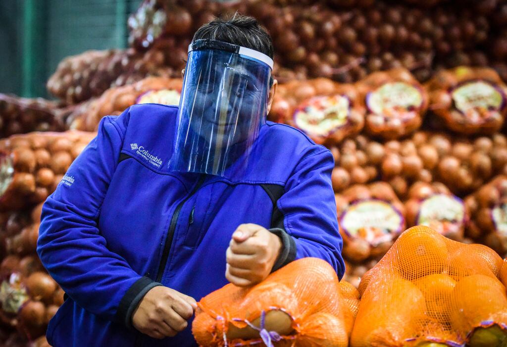 Una trabajadora se protege del Covid-19 en el mercado argentino de Tapiales