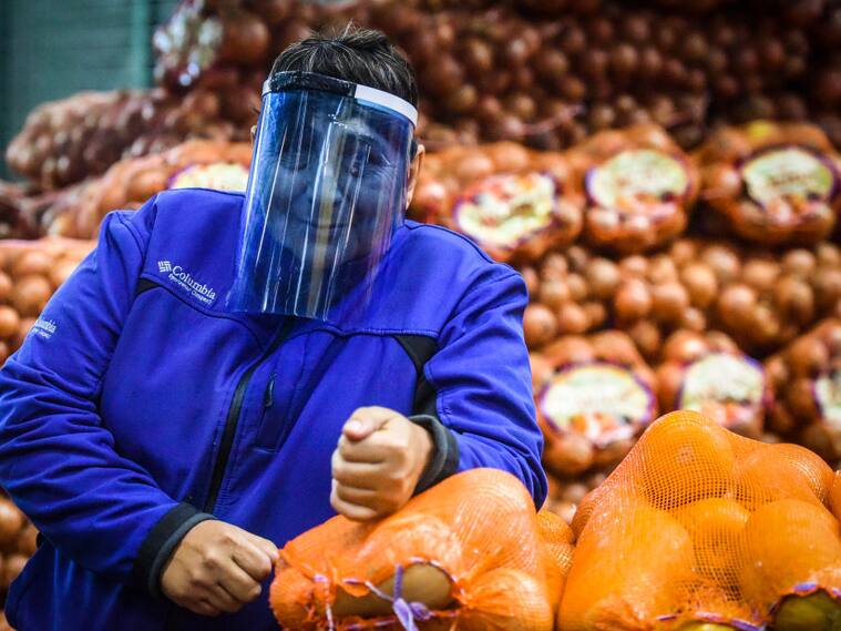 Una trabajadora se protege del Covid-19 en el mercado argentino de Tapiales