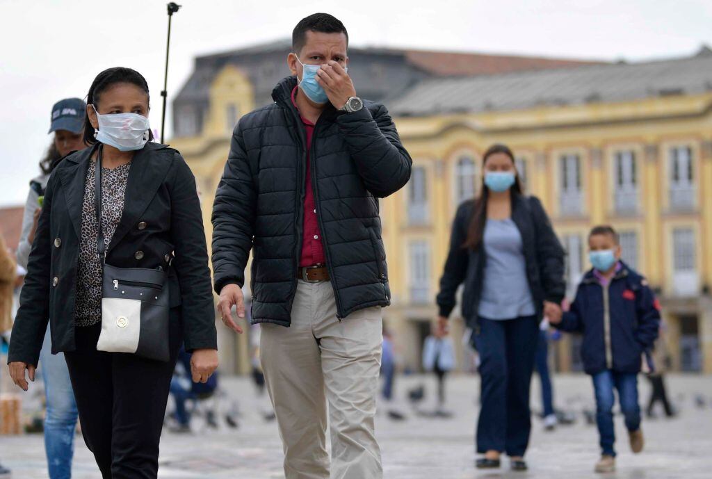 Las personas utilizan mascarillas mientras caminan por Bogotá en Colombia