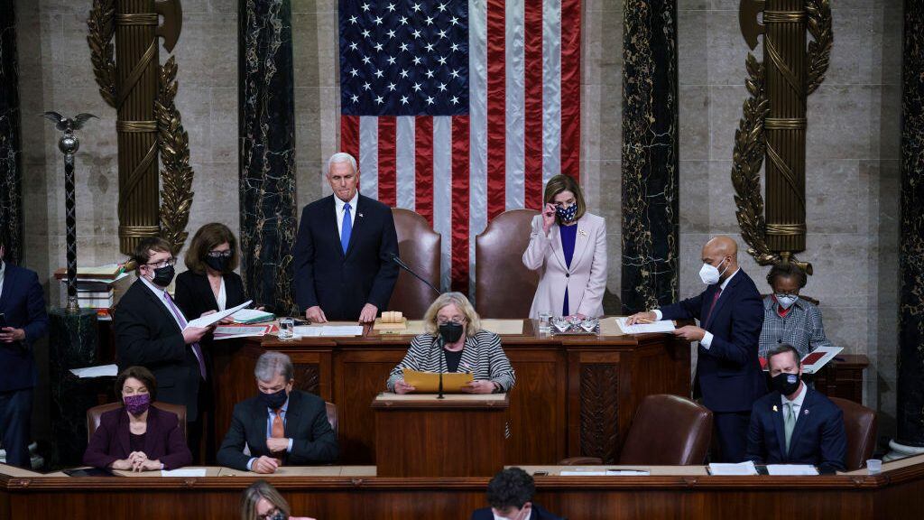 WASHINGTON, DC - JANUARY 07: Vice President Mike Pence and Speaker of the House Nancy Pelosi, D-Calif., prepare to read the final certification of Electoral College votes cast in November's presidential election during a joint session of Congress after working through the night, at the Capitol on January 7, 2021 in Washington, DC. Congress reconvened to ratify President-elect Joe Biden's 306-232 Electoral College win over President Donald Trump, hours after a pro-Trump mob broke into the U.S. Capitol and disrupted proceedings. (Photo by J. Scott Applewhite - Pool/Getty Images)