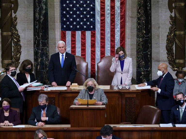 WASHINGTON, DC - JANUARY 07: Vice President Mike Pence and Speaker of the House Nancy Pelosi, D-Calif., prepare to read the final certification of Electoral College votes cast in November's presidential election during a joint session of Congress after working through the night, at the Capitol on January 7, 2021 in Washington, DC. Congress reconvened to ratify President-elect Joe Biden's 306-232 Electoral College win over President Donald Trump, hours after a pro-Trump mob broke into the U.S. Capitol and disrupted proceedings. (Photo by J. Scott Applewhite - Pool/Getty Images)