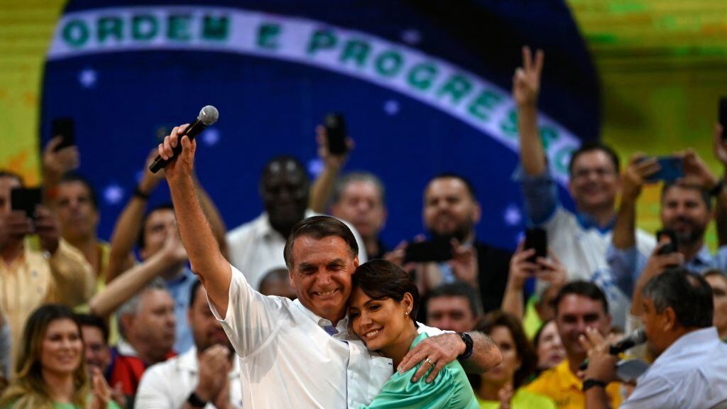 Brazils President Jair Bolsonaro (L) hugs his wife Michelle Bolsonaro during the Liberal Party (PL) national convention where he was officially appointed as candidate for re-election, at the Maracanazinho gymnasium in Rio de Janeiro, Brazil, on July 24, 2022. (Photo by MAURO PIMENTEL / AFP) (Photo by MAURO PIMENTEL/AFP via Getty Images)