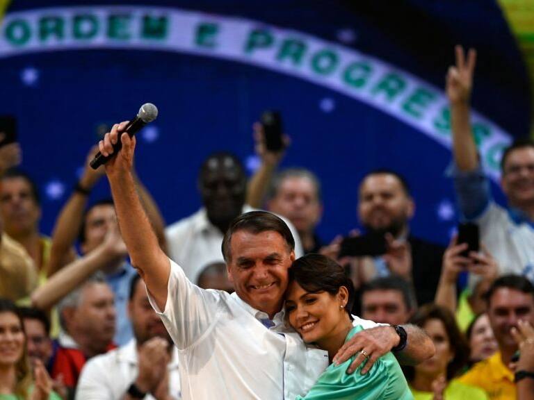 Brazils President Jair Bolsonaro (L) hugs his wife Michelle Bolsonaro during the Liberal Party (PL) national convention where he was officially appointed as candidate for re-election, at the Maracanazinho gymnasium in Rio de Janeiro, Brazil, on July 24, 2022. (Photo by MAURO PIMENTEL / AFP) (Photo by MAURO PIMENTEL/AFP via Getty Images)