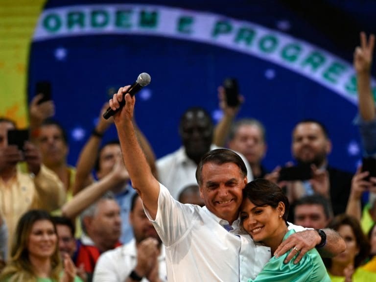 Brazils President Jair Bolsonaro (L) hugs his wife Michelle Bolsonaro during the Liberal Party (PL) national convention where he was officially appointed as candidate for re-election, at the Maracanazinho gymnasium in Rio de Janeiro, Brazil, on July 24, 2022. (Photo by MAURO PIMENTEL / AFP) (Photo by MAURO PIMENTEL/AFP via Getty Images)