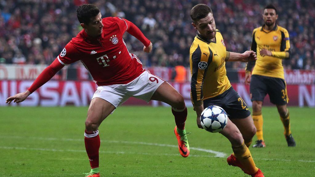 MUNICH, BAVARIA - FEBRUARY 15: The ball hits the hand of Shkodran Mustafi of Arsenal as he competes with Robert Lewandowski of Bayern Munich during the UEFA Champions League Round of 16 first leg match between FC Bayern Muenchen and Arsenal FC at Allianz Arena on February 15, 2017 in Munich, Germany. (Photo by Chris Brunskill Ltd/Getty Images)