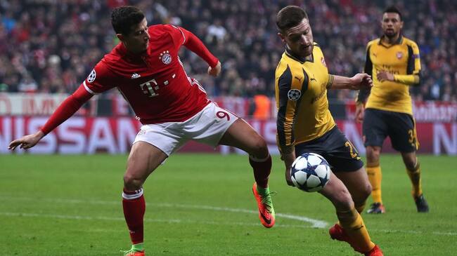 MUNICH, BAVARIA - FEBRUARY 15: The ball hits the hand of Shkodran Mustafi of Arsenal as he competes with Robert Lewandowski of Bayern Munich during the UEFA Champions League Round of 16 first leg match between FC Bayern Muenchen and Arsenal FC at Allianz Arena on February 15, 2017 in Munich, Germany. (Photo by Chris Brunskill Ltd/Getty Images)
