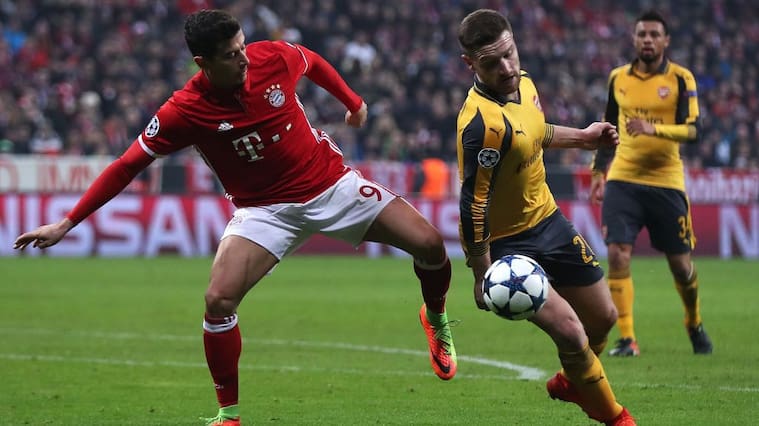 MUNICH, BAVARIA - FEBRUARY 15: The ball hits the hand of Shkodran Mustafi of Arsenal as he competes with Robert Lewandowski of Bayern Munich during the UEFA Champions League Round of 16 first leg match between FC Bayern Muenchen and Arsenal FC at Allianz Arena on February 15, 2017 in Munich, Germany. (Photo by Chris Brunskill Ltd/Getty Images)