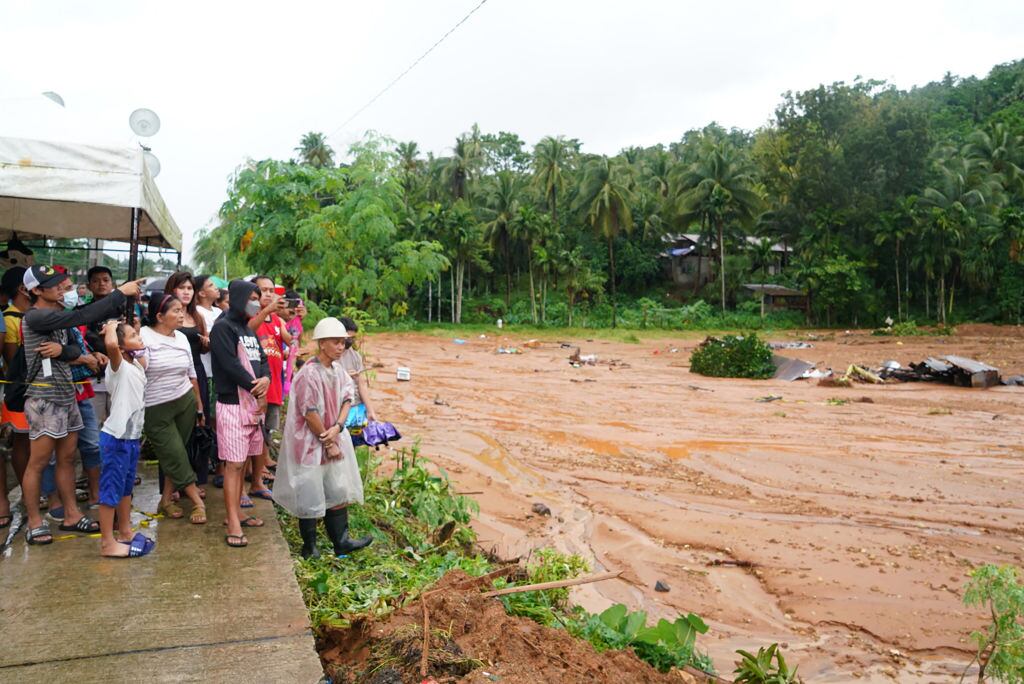 Residentes de la Villa Bunga observan la riada por las inundaciones