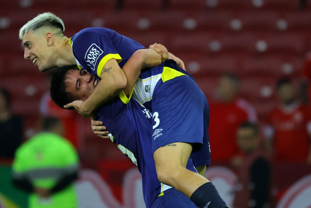 Rosario Central's defender Gonzalo Sandez (top) celebrates with Rosario Central's midfielder Kevin Ortiz after winning the Copa Sudamericana knockout round playoff second leg football match between Brazil's Internacional and Argentina's Rosario Central at the Beira-Rio stadium in Porto Alegre, Brazil on July 23, 2024. (Photo by SILVIO AVILA / AFP) (Photo by SILVIO AVILA/AFP via Getty Images)
