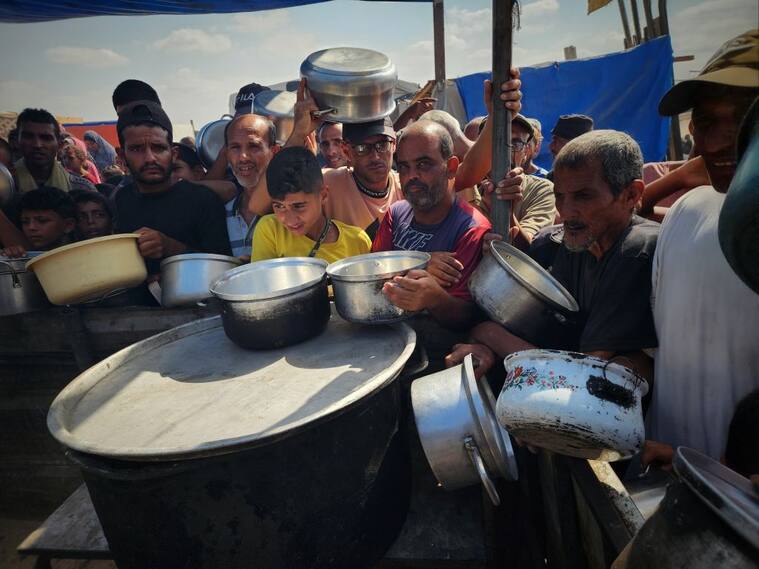En la Franja de Gaza se agolpan para recibir alimentos en sus platos, mientras esperan comida y sobrevivir los ataques militares de Israel