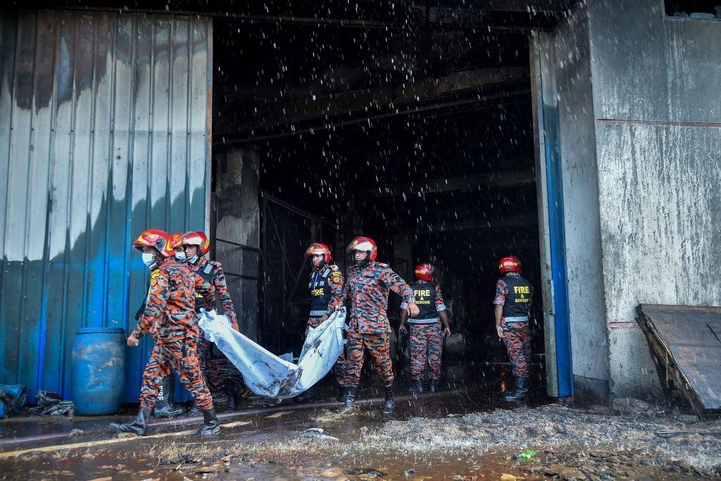 Bomberos trasladan el cuerpo de una persona muerte en el siniestro en Bangladesh