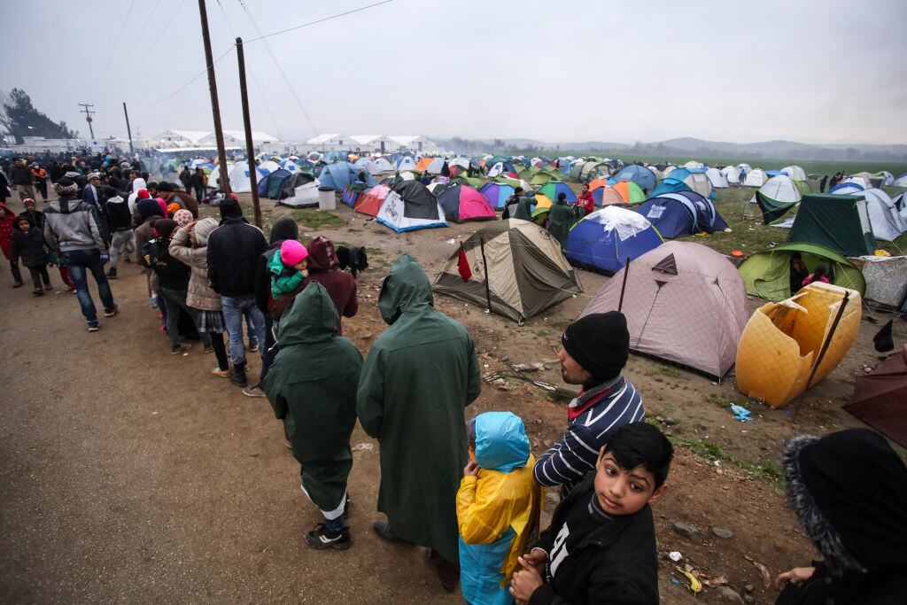 Refugiados en Grecia realizan una fila para recibir alimentos