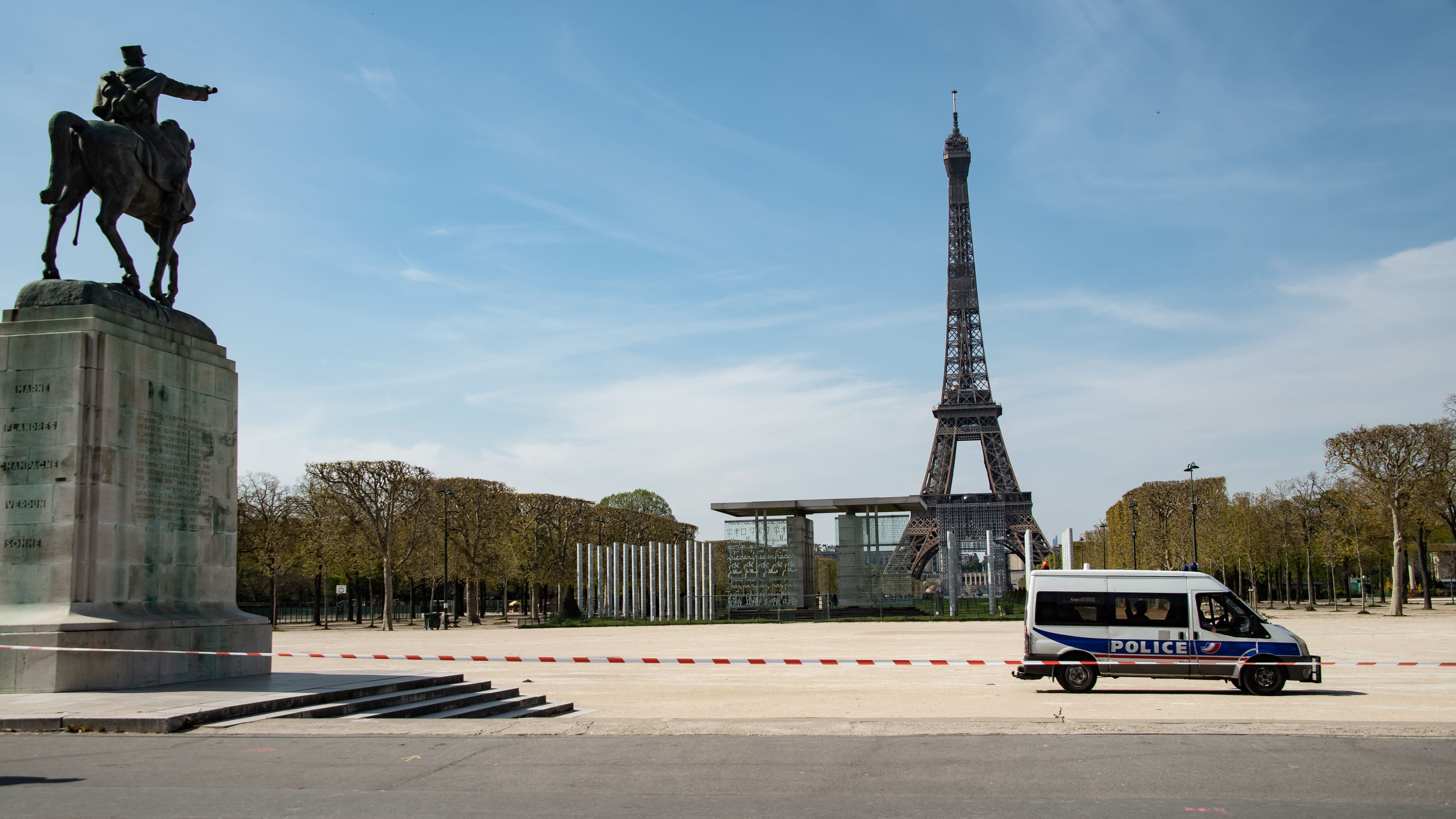 A police van is parked in the closed Jardin du Champs de Mars garden in front of the Eiffel tower in Paris on April 7, 2020, the 22nd day of a lockdown in France aimed at curbing the spread of the COVID-19 pandemic, caused by the novel coronavirus. (Photo by BERTRAND GUAY / AFP) (Photo by BERTRAND GUAY/AFP via Getty Images)