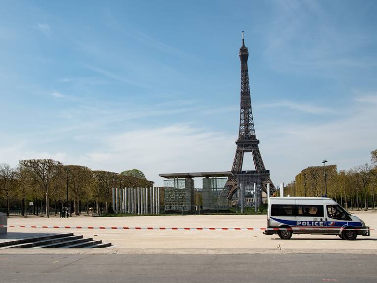 A police van is parked in the closed Jardin du Champs de Mars garden in front of the Eiffel tower in Paris on April 7, 2020, the 22nd day of a lockdown in France aimed at curbing the spread of the COVID-19 pandemic, caused by the novel coronavirus. (Photo by BERTRAND GUAY / AFP) (Photo by BERTRAND GUAY/AFP via Getty Images)