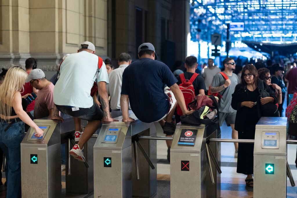 Las personas saltan los torniquetes en el sistema de transporte en Buenos Aires, ante la crisis económica que incluye alzas en el transporte y una fuerte inflación.