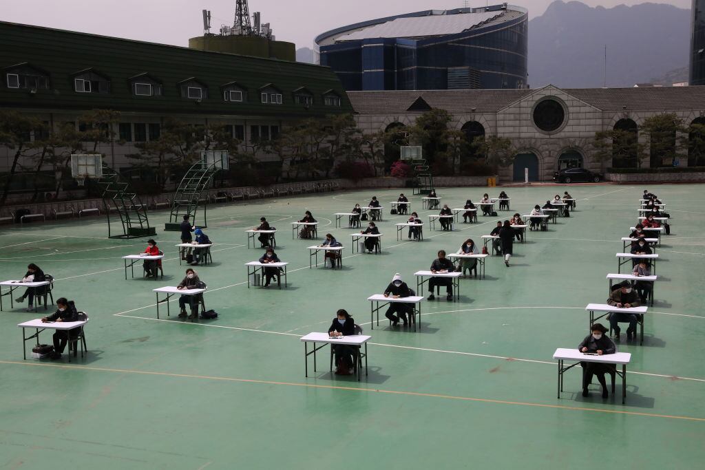 Estudiantes rinden una prueba en un patio por el Covid-19 en Corea del Sur