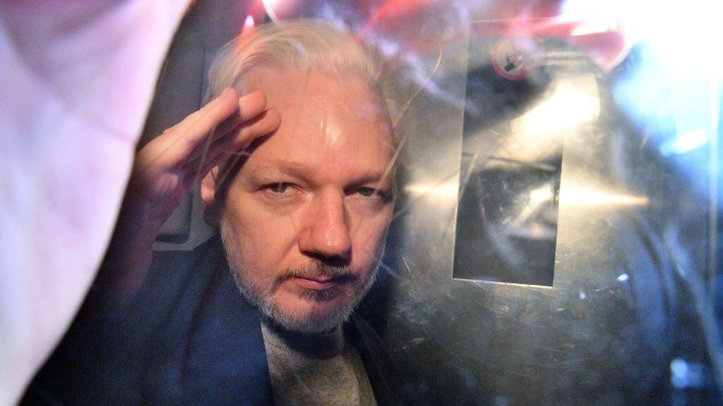 WikiLeaks founder Julian Assange gestures from the window of a prison van as he is driven out of Southwark Crown Court in London on May 1, 2019, after having been sentenced to 50 weeks in prison for breaching his bail conditions in 2012. - A British judge on Wednesday sentenced WikiLeaks founder Julian Assange to 50 weeks in prison for breaching his bail conditions in 2012. Assange took refuge in Ecuador's London embassy to avoid extradition to Sweden and was only arrested last month after Ecuador withdrew his asylum status. (Photo by Daniel LEAL / AFP) (Photo by DANIEL LEAL/AFP via Getty Images)