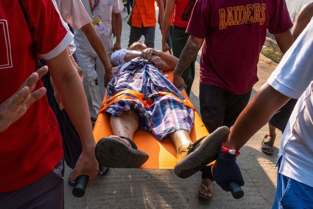 Manifestante herido por disparo es llevado por ciudadanos en Rangún