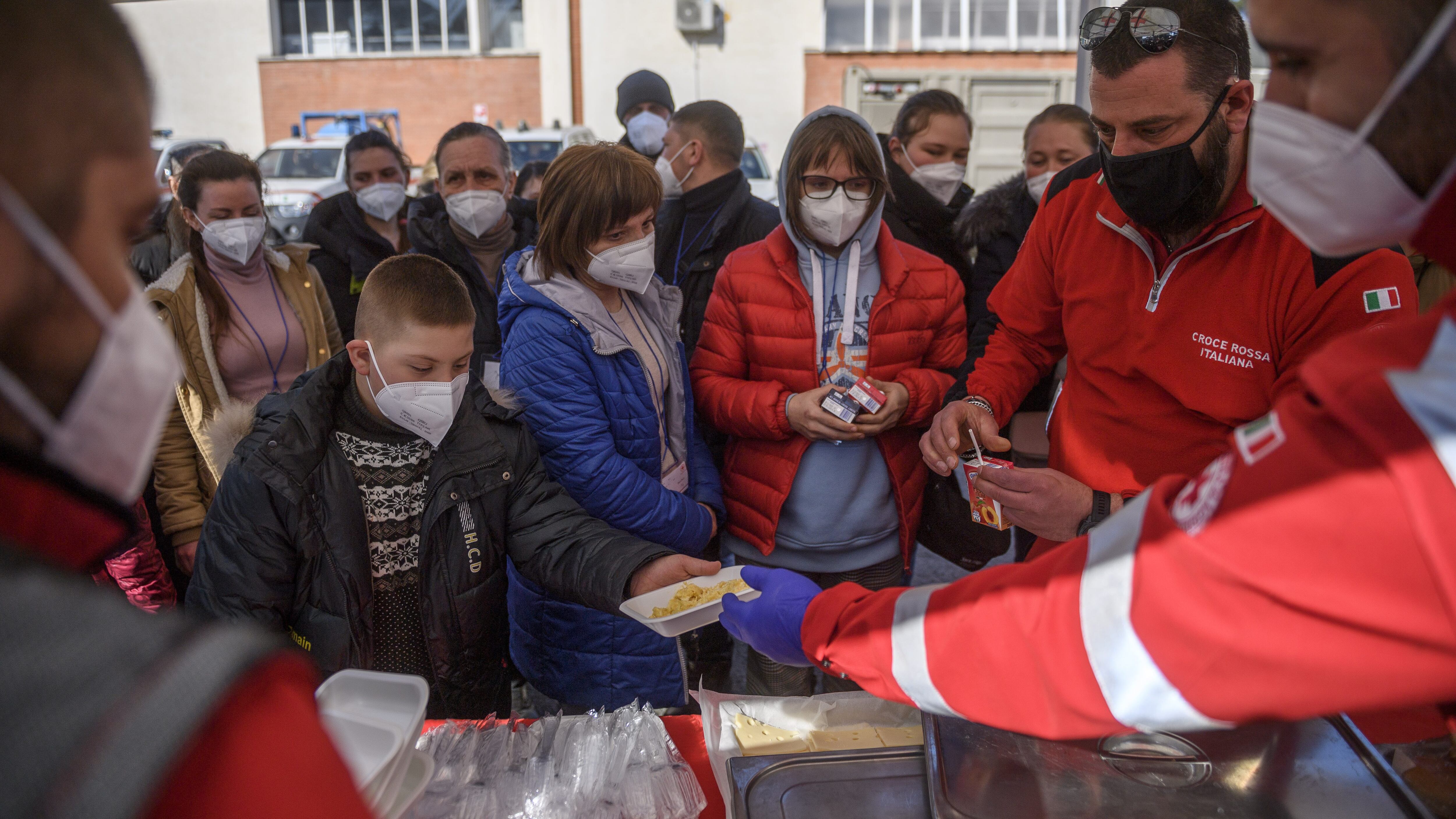 ROME, ITALY - MARCH 22: Ukrainian refugees evacuated from Lviv receive hot meals brought by Italian Red Cross volunteers, on March 22, 2022 in Rome, Italy. About 80 frail people including children, elderly and disabled were evacuated from Lutsk, Kharhiv and Kiev by the Italian Red Cross in collaboration with the Civil Protection Department. (Photo by Antonio Masiello/Getty Images)